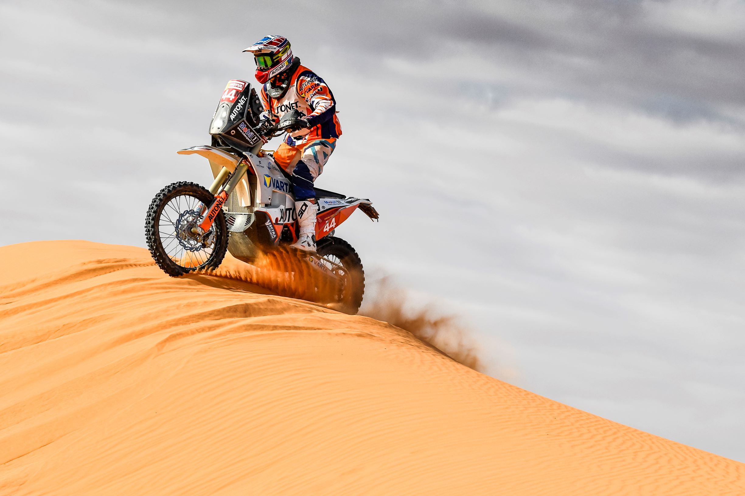 Man driving motorcycle on a sand dune in the desert