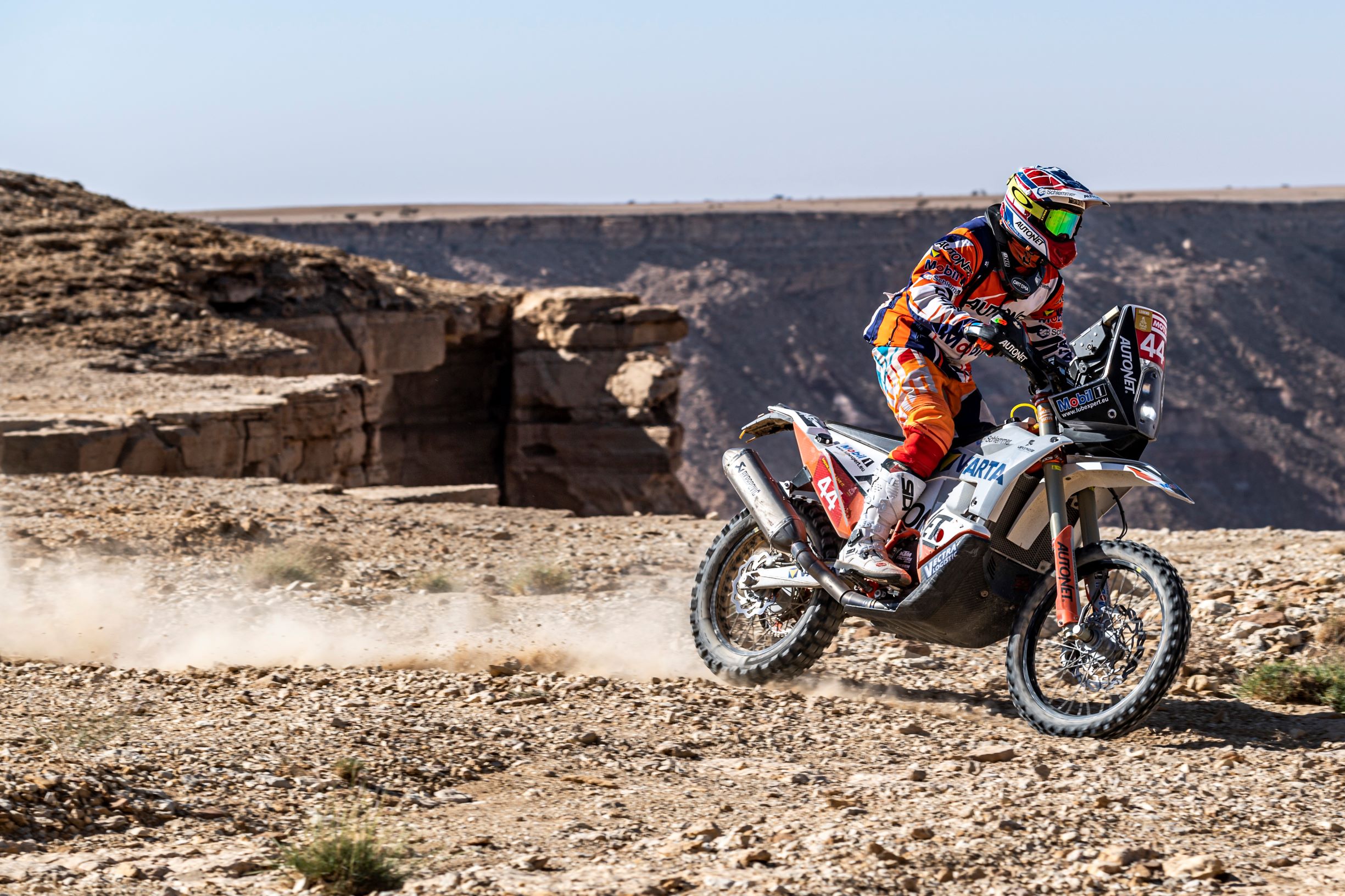 Man driving motorcycle along canyon in the desert