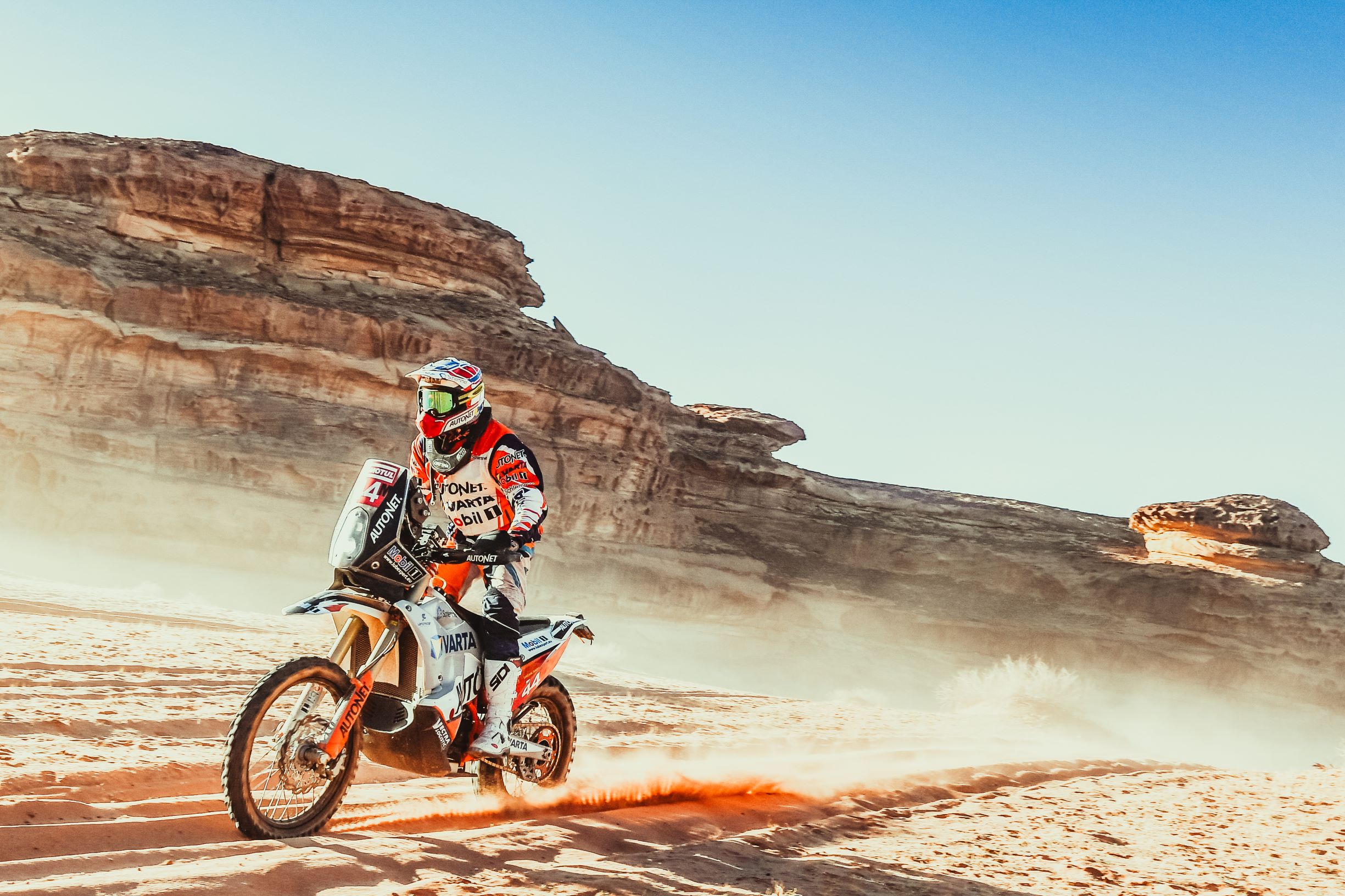 Man driving motorcycle along canyon in the desert