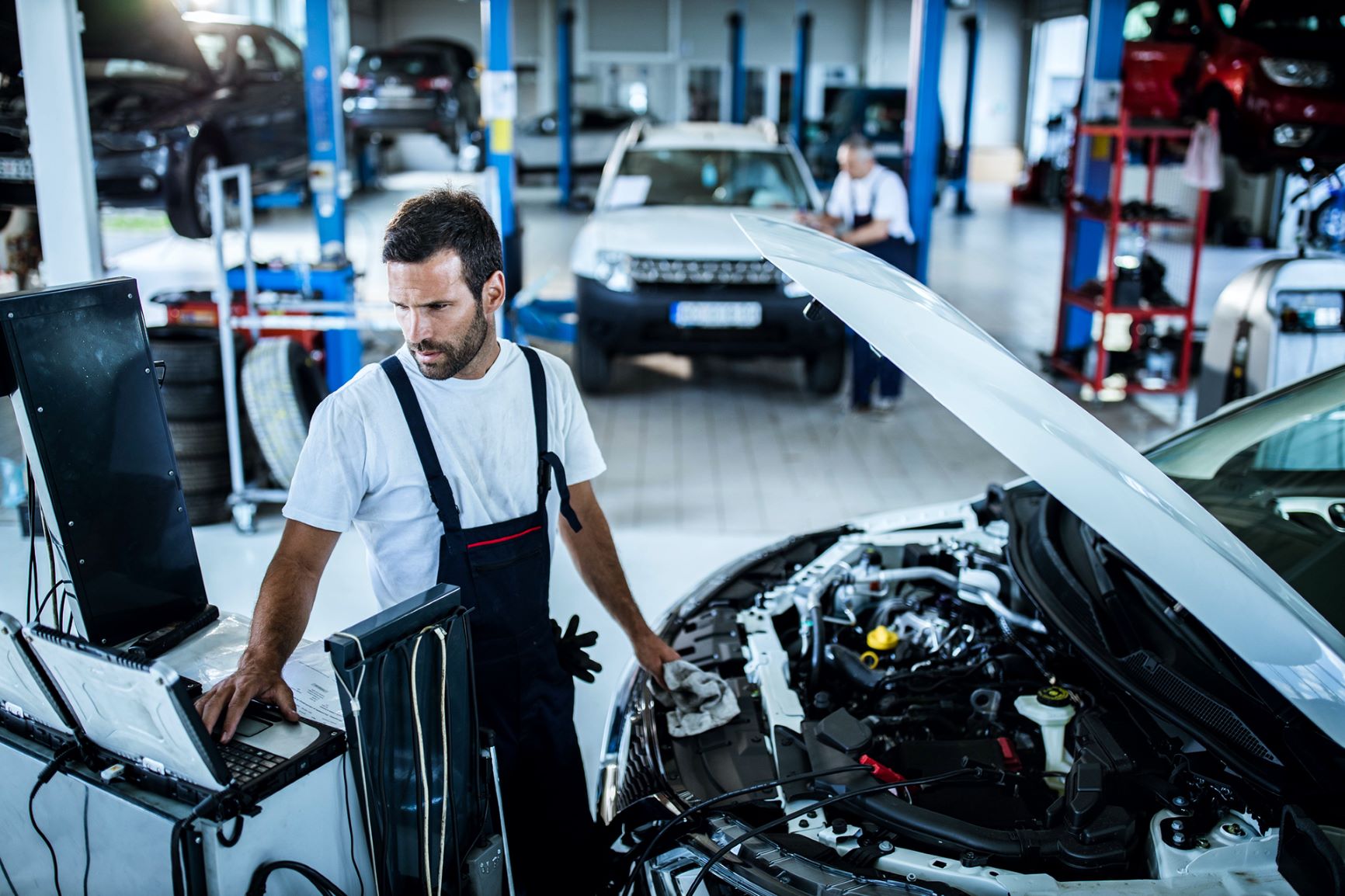 Mechanic working on car in shop