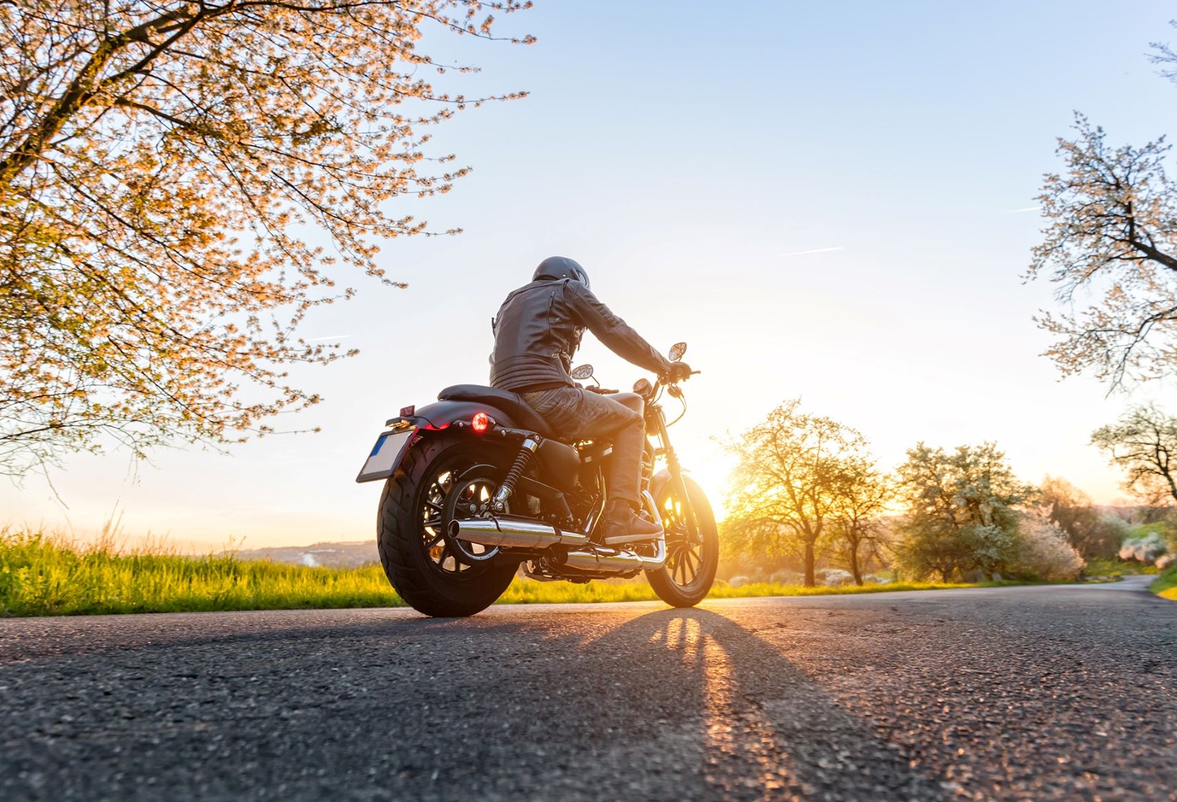 Fotografía en ángulo bajo de una motocicleta en la acera al atardecer