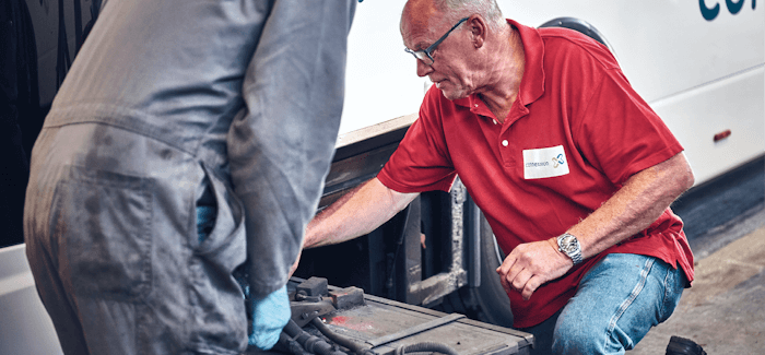 Two Men Working on a Bus Engine