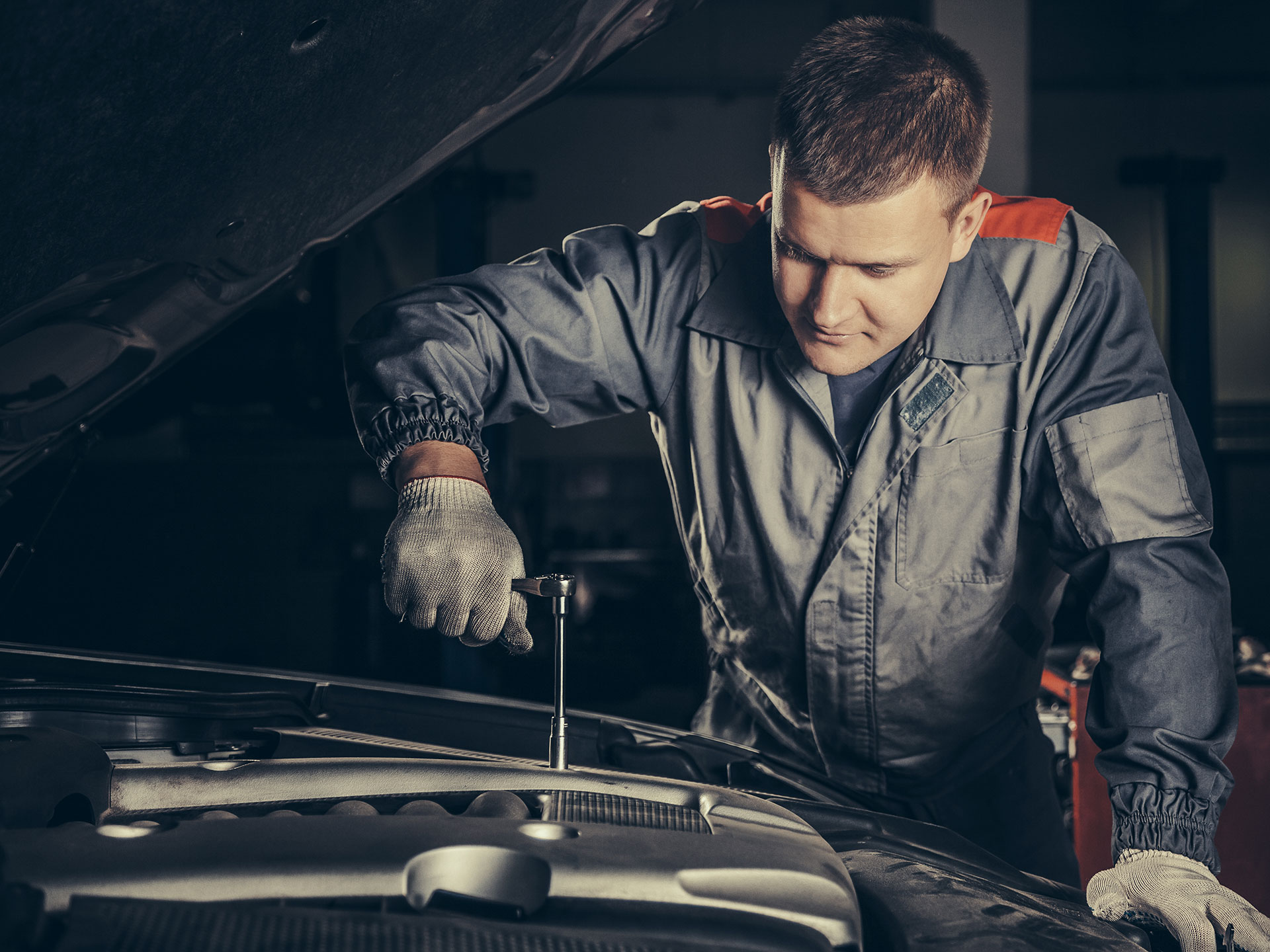 Mekaniker i arbete under bilens motorhuv