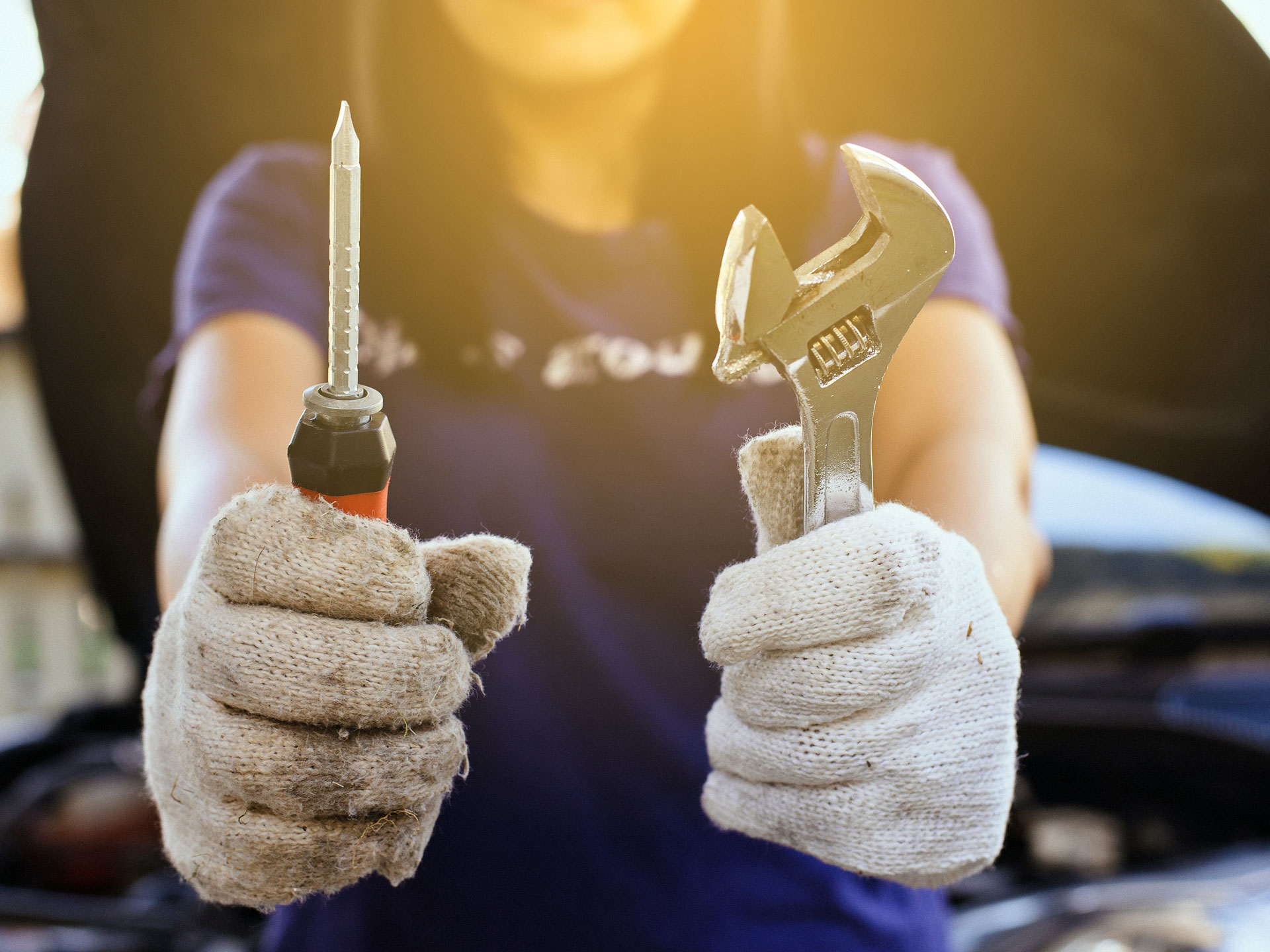 Woman wearing gloves and holding tools